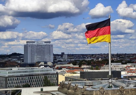View from the Reichstag dome of a German flag in the wind with the Charité bed tower, Reichstag