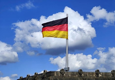 View from the Reichstag dome of a German flag in the wind in front of a cloud, Reichstag building,