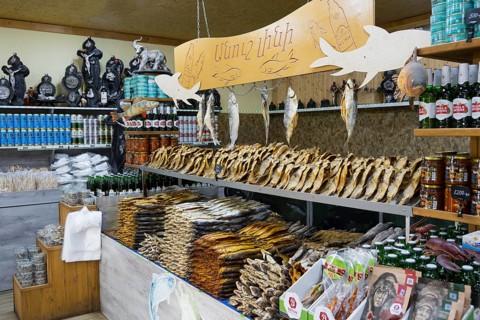 Various products and fish are arranged in a decorative market stall, fish sale, Tsovagyugh, Lake