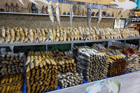 Different types of fish are displayed on a decorated shelf in a market, fish sale, Tsovagyugh, Lake