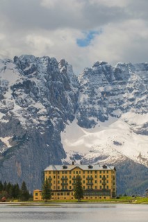 View over Lake Misurina to a building on the shore of the lake with a view towards the mountain