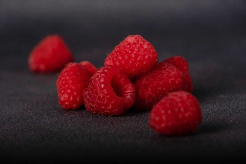 Red raspberries on dark background, selective focus