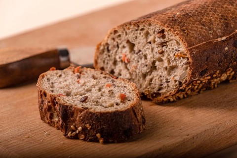 Slices of whole grain bread with carrots and seeds, close-up