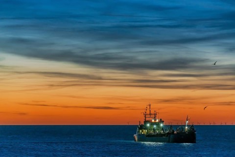 Coastal defence, hopper dredger, suction dredger in the evening light off the coast of the North