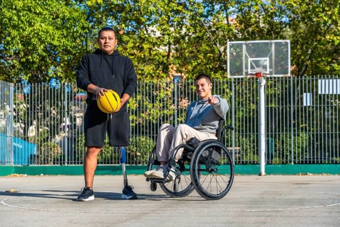 Men with diverse disabilities, one using a prosthetic leg and holding a basketball, the other