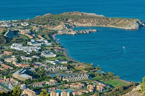 Coastal landscape of Kolymbia with bay and mountainous surroundings on a clear day, Church of the