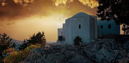 The white chapel of the Virgin Mary Tsambika (Kyra Psili) in front of a dramatic sunset sky with