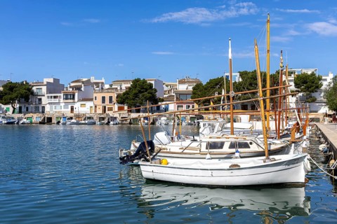 Portocolom fishing village on Majorca with boats and colourful houses Holiday by the sea in