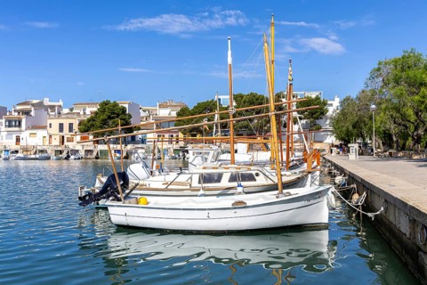 Portocolom fishing village on Majorca with boats and colourful houses Holiday by the sea in