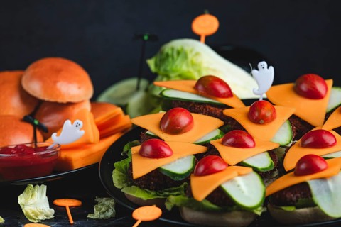 Burger buns with cheese, tomatoes, salad and Halloween decorations