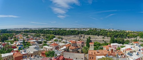 Historic old town with colourful houses and green trees under a clear blue sky, Roloi Clock Tower,