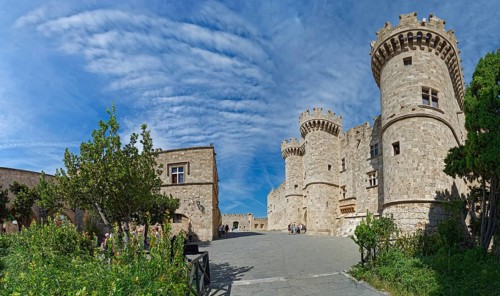 Wide view of a medieval castle with towers and stone walls under a cloudy sky, Grand Master's