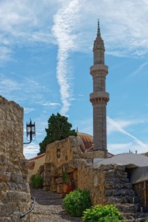 A minaret with a blue sky and ancient walls in a tranquil, historic setting, Suleiman Mosque,