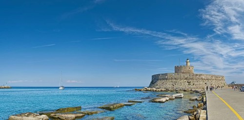Fort of Saint Nikolaos stretches along the coast in the bright sunshine, Mandraki harbour, Medieval