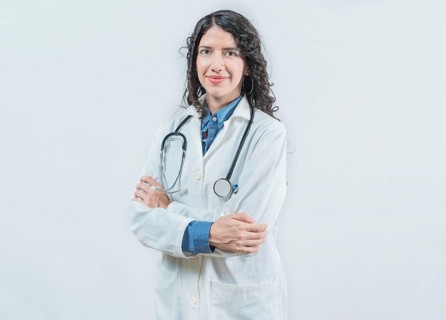 Portrait of smiling latin female doctor with crossed arms on isolated background. Success young