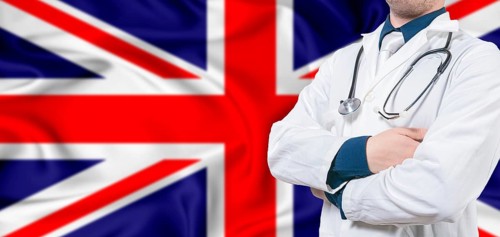 United Kingdom healthcare concept. Male doctor on United Kingdom flag. Doctor with crossed arms on