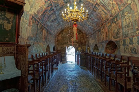 Historic church interior with paintings and a decorative chandelier, conveying a calm and venerable