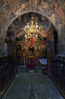 Magnificently decorated church interior with frescoes and a large candlestick that creates a