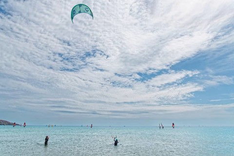 Prasonisi's expansive sea under a big sky with kitesurfers. Lively, sporty atmosphere, Prasonisi,
