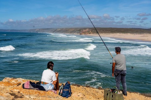 Anglers on the cliffs at the viewpoint above Praia da Bordeira beach, near Carrapateira, popular