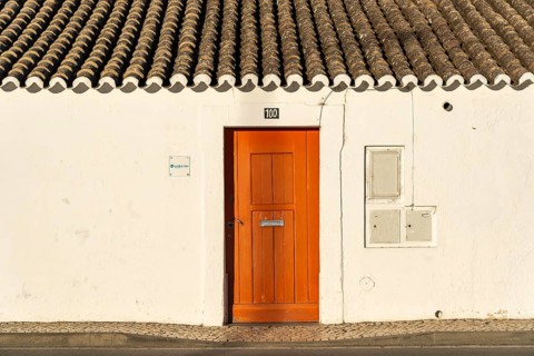 House with orange door, old building in the historic centre of Tavira, Algarve, Portugal