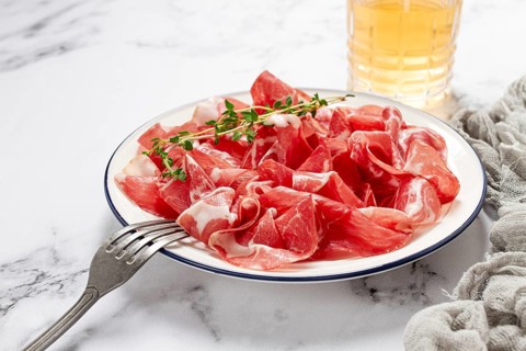 Plate with sliced cured meat, pork neck, prosciutto coppa, Italian delicacy
