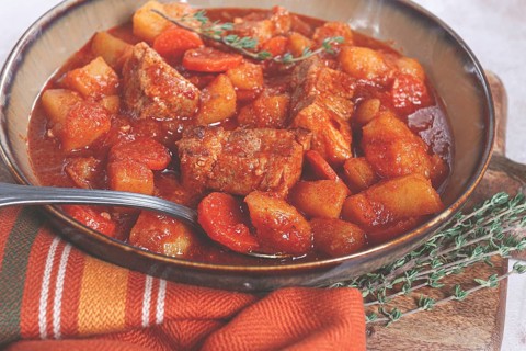 Meat goulash with potatoes and carrots, sweet peppers, in a saucepan, top view, traditional