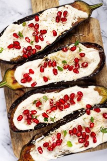 Fried eggplant with sauce, decorated with microgreens and pomegranate seeds, eggplant appetizer,