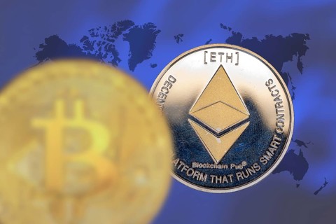 (Photomontage) Cryptocurrencies: Symbolic Bitcoin and Ethereum, cropped in front of a world map