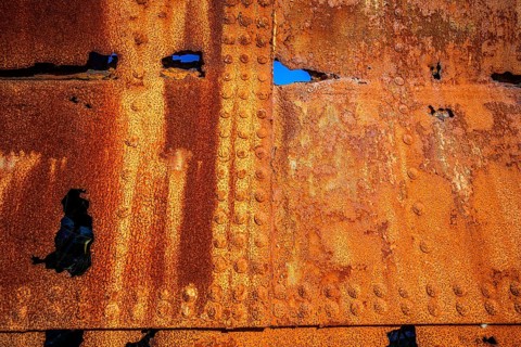 The rough texture of heavily corroded iron plates on the hull of. derelict ship. British Columbia,