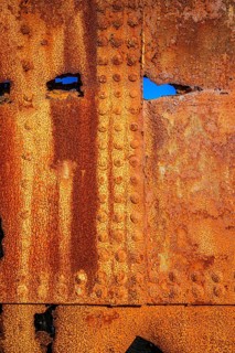 The rough texture of heavily corroded iron plates on the hull of. derelict ship. British Columbia,