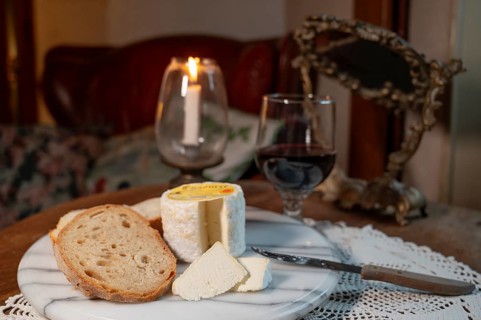 Chaource cheese presented sliced with bread and red wine in warm candlelight, typical of the