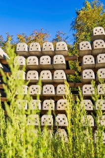 Many stacked concrete blocks with plants in the foreground, Hermann Hessebahn construction site,