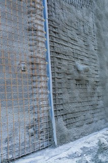 Close-up of a concrete wall with visible wire mesh on a construction site, Hermann Hessebahn