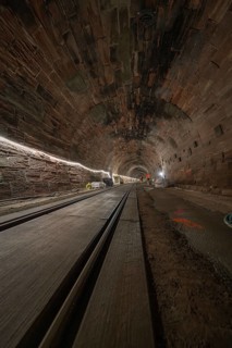 Dark tunnel with rails and lighting along the tunnel walls, construction of the Hermann Hesse
