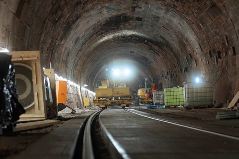 Construction work in the tunnel with machines and lighting along the tracks, construction of the
