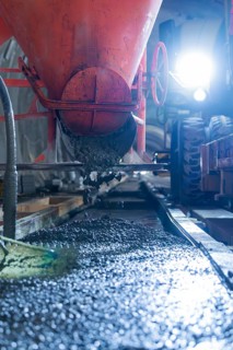 Concrete is poured from a construction vehicle in the tunnel. The area is brightly lit,