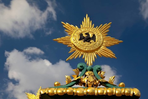 Golden star with black eagle and the Latin inscription suum cuique, to each his own, detail on the