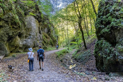 Trailfinger Gorge near Seeburg in the Swabian Alb. Man and woman with dog on a hike through the