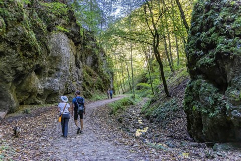 Trailfinger Gorge near Seeburg in the Swabian Alb. Man and woman with dog on a hike through the