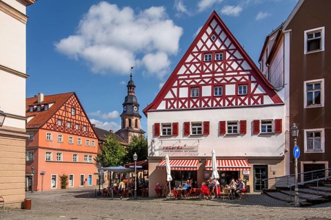 Half-timbered houses with street café and hospital church in the old town, beer town Kulmbach,
