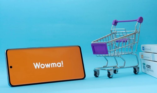 Dhaka, Bangladesh- 03 July 2025: Smartphone with wowma logo next to a small shopping cart and boxes