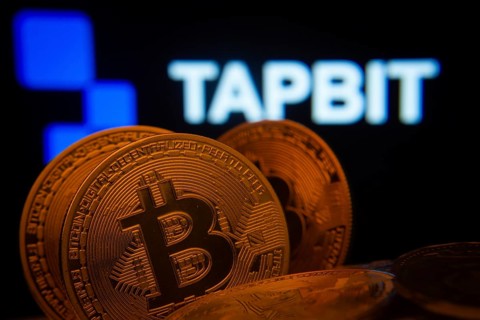 Dhaka, Bangladesh- 20 Sep 2025: Close-up of Bitcoin coins with thex Tapbit logo visible on a screen