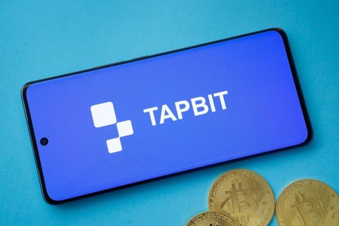 Dhaka, Bangladesh- 19 Sep 2025: Tapbit logo on smartphone screen near Bitcoin coin and QR code on