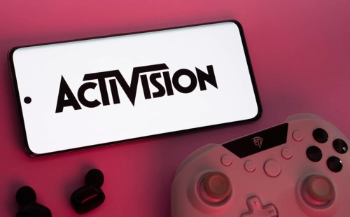 Dhaka, Bangladesh- 23 Sep 2025: Smartphone with Activision logo, game controller, and earbuds on a