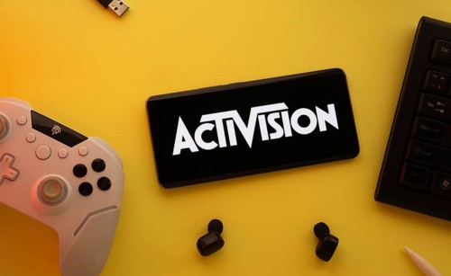 Dhaka, Bangladesh- 23 Sep 2025: Smartphone with Activision logo, game controller, and earbuds on a