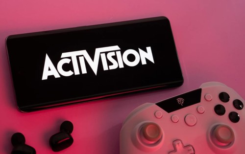 Dhaka, Bangladesh- 23 Sep 2025: Smartphone with Activision logo, game controller, and earbuds on a
