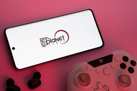 Dhaka, Bangladesh- 23 Sep 2025: Smartphone with 5th planet games logo, game controller, and earbuds