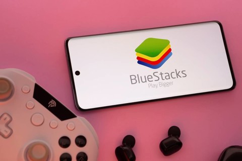 Dhaka, Bangladesh- 23 Sep 2025: Smartphone with BlueStacks logo, game controller, and earbuds on a