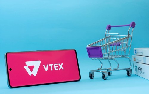 Dhaka, Bangladesh- 03 July 2025: Smartphone with VTEX logo next to a small shopping cart and boxes